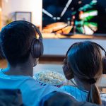 Man and woman watching TV with headphones