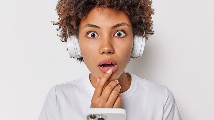 Woman wearing headphones surprised